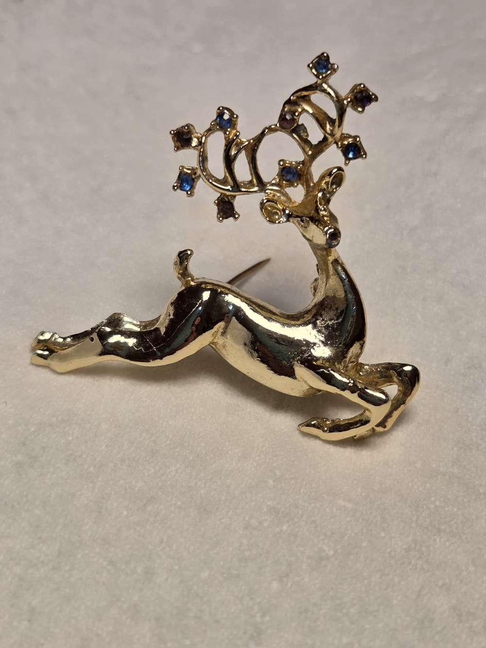 Gold-tone Reindeer Brooch with Blue Accent Stones